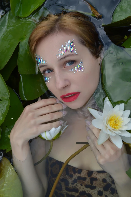 a woman with glitter on her face holding a flower, an album cover, inspired by David LaChapelle, unsplash, renaissance, lily pads, better known as amouranth, white facepaint, koi