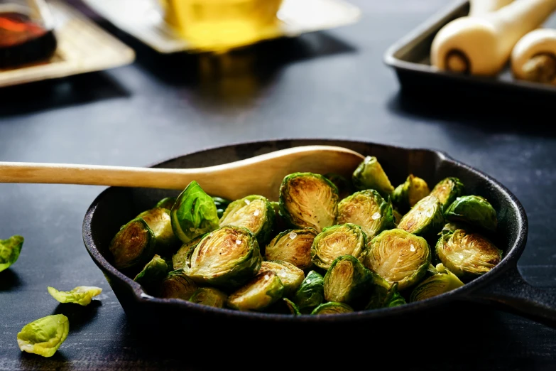 a pan filled with brussel sprouts and a wooden spoon, a still life, by Carey Morris, unsplash, square, grilled artichoke, 3 - piece, various sizes