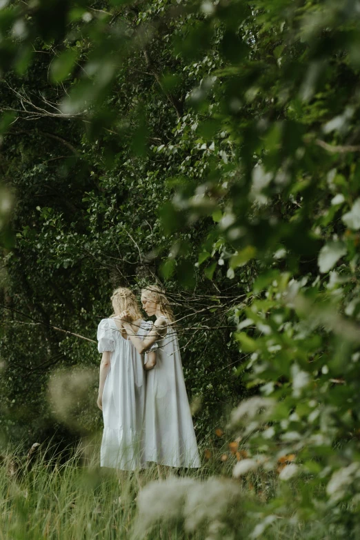 a couple of women standing next to each other in a forest, inspired by Elsa Beskow, unsplash, romanticism, wearing robes of silver, film movie still, ignant, concert