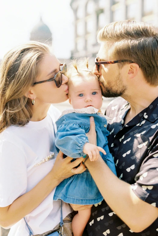 a man kissing a woman while holding a baby, a picture, by Julia Pishtar, pexels, with square glasses, anna nikonova aka newmilky, sunny day time, perfect android girl family