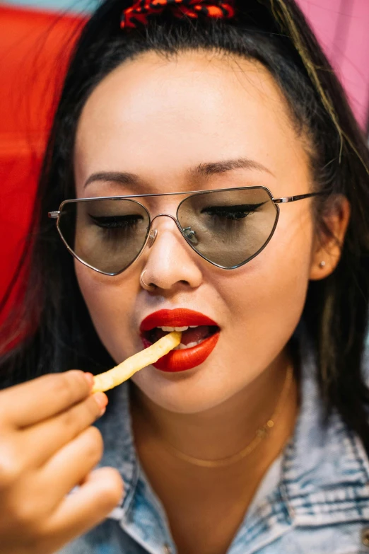 a woman is brushing her teeth with a toothbrush, an album cover, by Julia Pishtar, trending on pexels, serving fries, asian face, wear ray - ban glass, luscious red lips