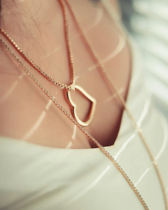 a close up of a person wearing a necklace, inspired by Louis Hersent, trending on instagram, rose gold heart, product introduction photo