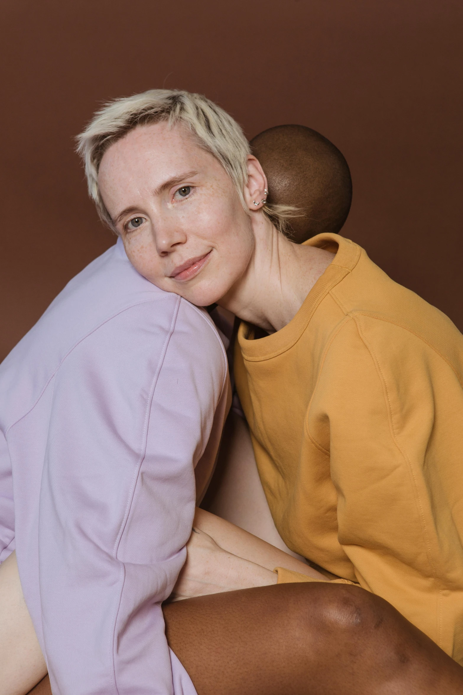 a man and a woman sitting next to each other, an album cover, by Anna Füssli, lesbian embrace, warm color clothes, ignant, with a white complexion