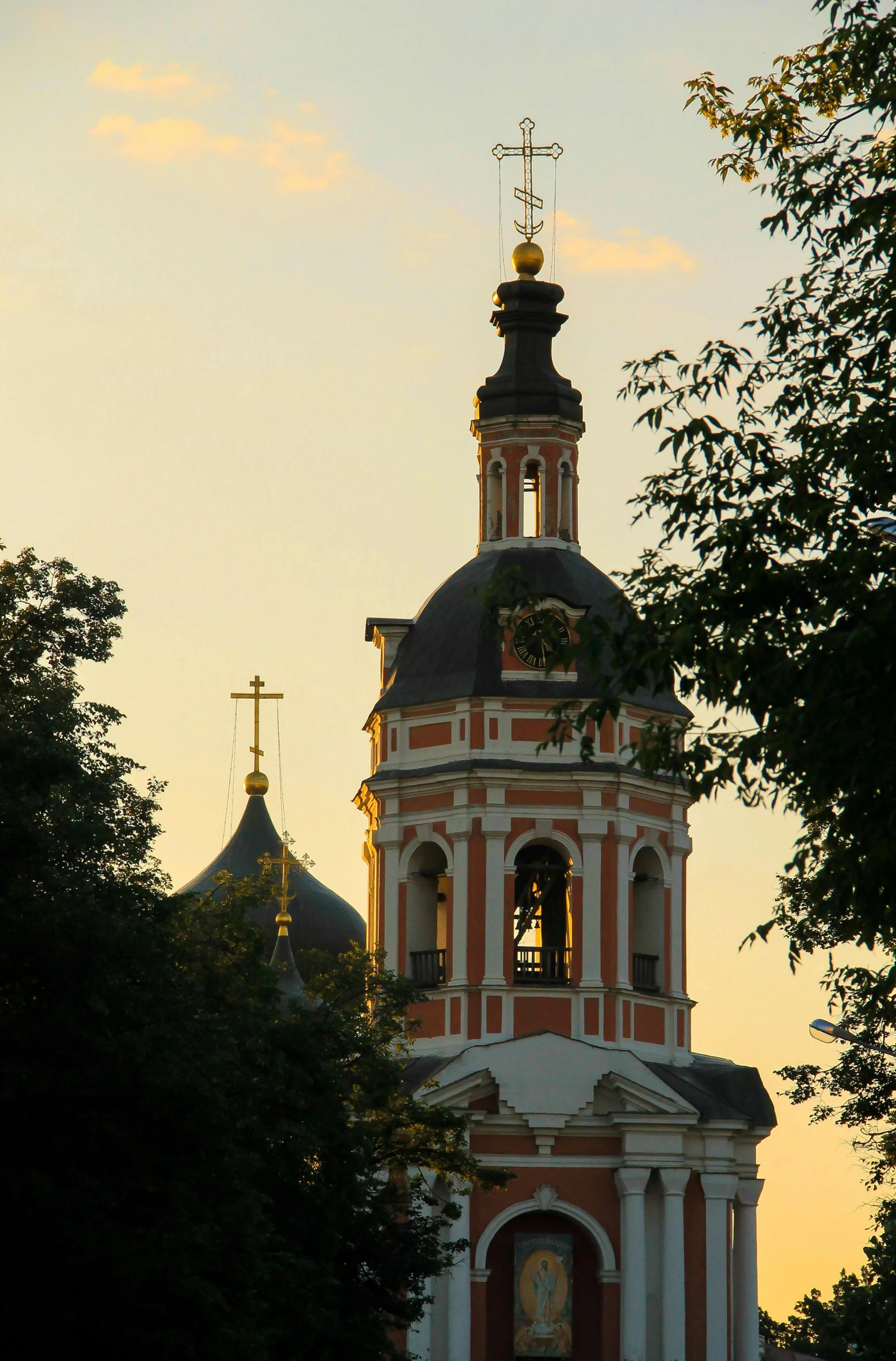 a tall tower with a clock on top of it, inspired by Konstantin Vasilyev, baroque, at sunset, rounded roof, upclose, orthodox icons