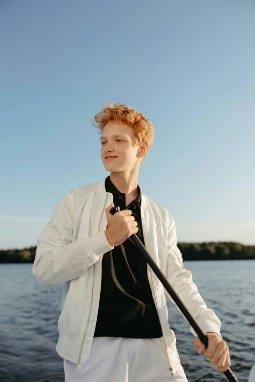 a man standing on a boat holding a paddle, unsplash, renaissance, red haired teen boy, white jacket, headshot profile picture, ignant