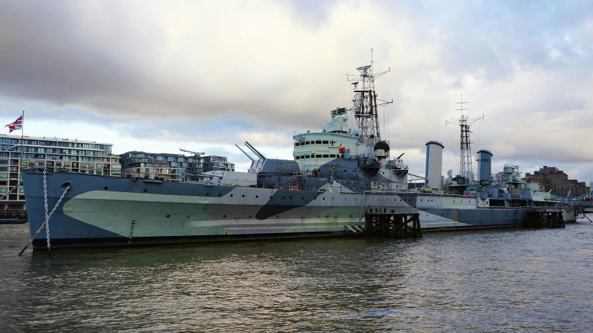 a large battleship sitting on top of a body of water, in london