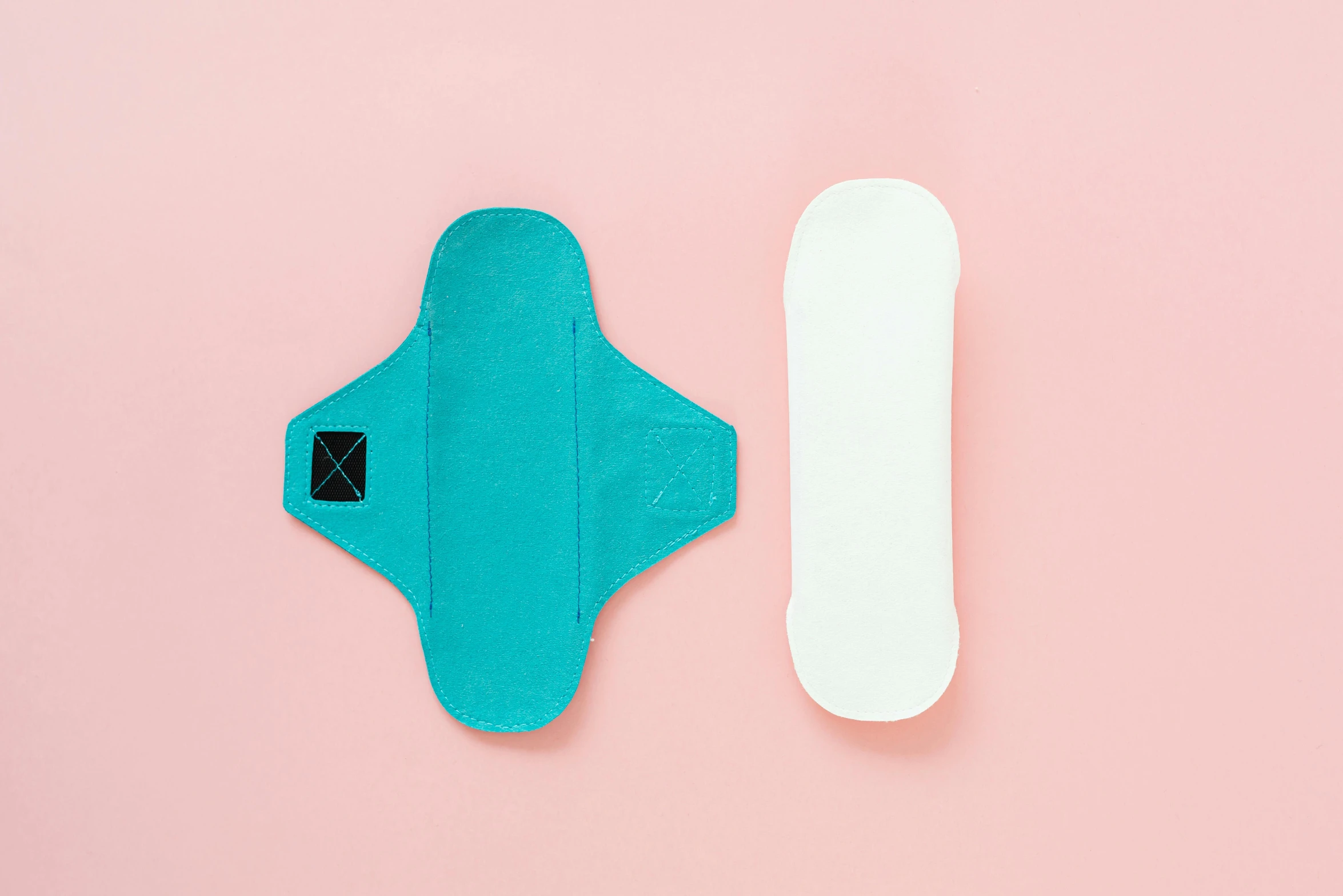 two sanitary pads next to each other on a pink surface, by Julia Pishtar, white and teal garment, view from bottom to top, various posed, detailed product image