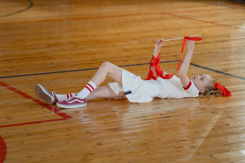 a little girl laying on top of a basketball court, inspired by Mia Brownell, dribble contest winner, happening, chinese ribbon dance, holding a giant flail, promo image, daniil kudriavtsev