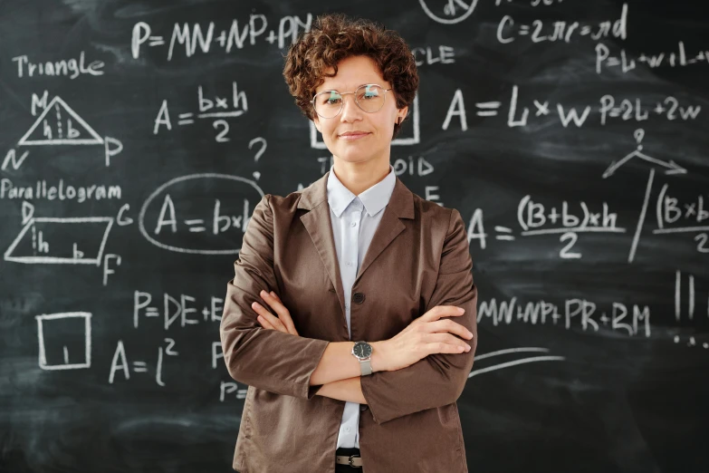 a woman standing in front of a blackboard, by Matthias Stom, pexels, wearing a suit and glasses, avatar image, brown, nikolay georgiev