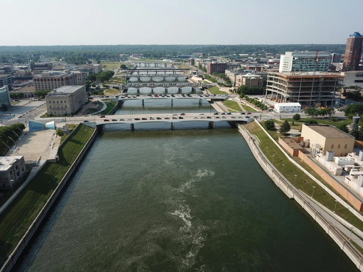 a river running through a city next to tall buildings, iowa, wall of water either side, drone photo, 2022 photograph