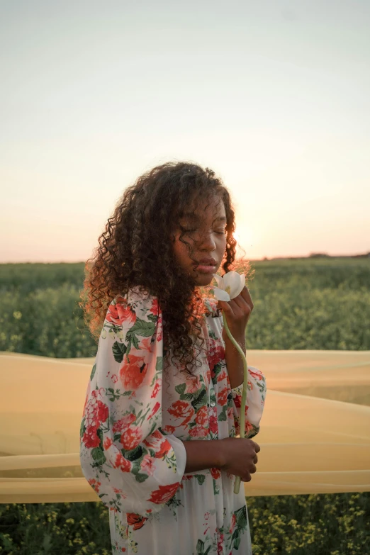 a woman standing in a field talking on a cell phone, a picture, trending on unsplash, renaissance, light skinned african young girl, desert flowers, clothes made out of flower, high quality photo