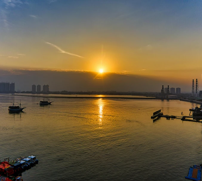 a large body of water filled with lots of boats, by Jan Tengnagel, pexels contest winner, baotou china, sunset panorama, calcutta, with the sun shining on it