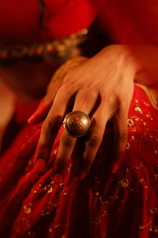 a woman in a red dress with a ring on her finger, an album cover, pexels, renaissance, provocative indian, film still, golden glow, ritual