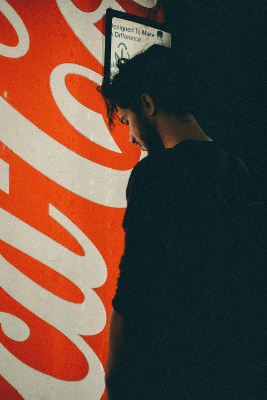 a man standing in front of a coca cola sign, poster art, trending on unsplash, black and orange, profile image, pensive, portrait of jughead jones