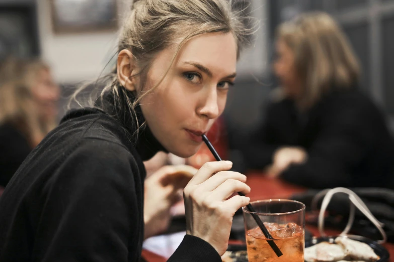 a woman sitting at a table drinking a drink, pexels contest winner, avatar image, sydney sweeney, cold drinks, profile image
