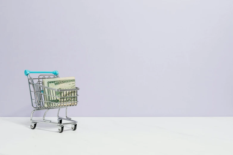 a shopping cart filled with money sitting on top of a white floor, purple accents, muted colors with minimalism, at target, promo image