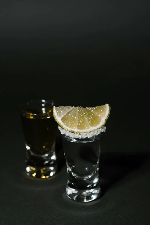 two shot glasses filled with liquid and a slice of lemon, a portrait, pexels, mexican standoff, in, portrait of dangerous, long