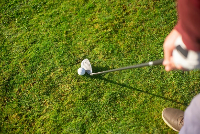 a person taking a swing at a golf ball, by Romain brook, unsplash, realism, top down photo at 45 degrees, giant wooden club, infested with pitch green, soft surfaces
