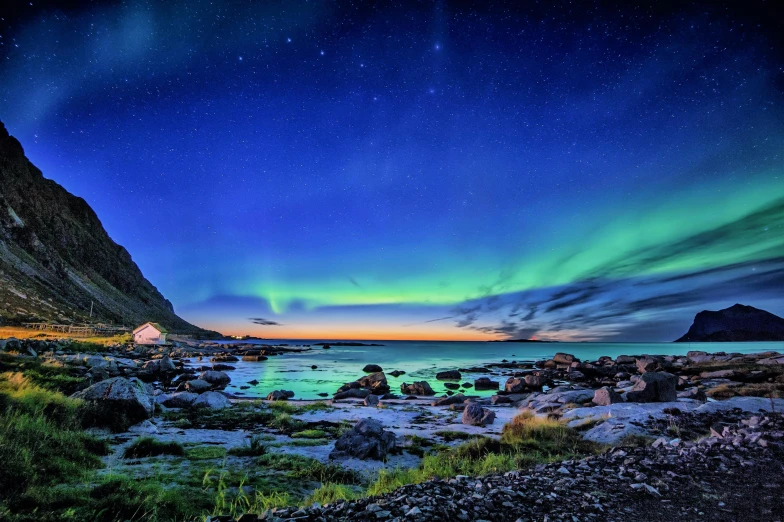 the aurora lights in the sky above a body of water, by Julia Pishtar, near the seashore, multicoloured, conde nast traveler photo