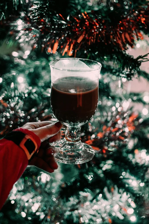 a person holding a wine glass in front of a christmas tree, ice coffee, absinthe, brown, thumbnail