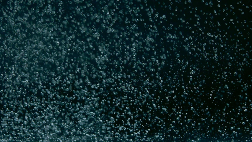 a close up of water bubbles in the air, an album cover, by Attila Meszlenyi, unsplash, digital art, dark blue atmosphere, ignant, micro detail, black and teal paper