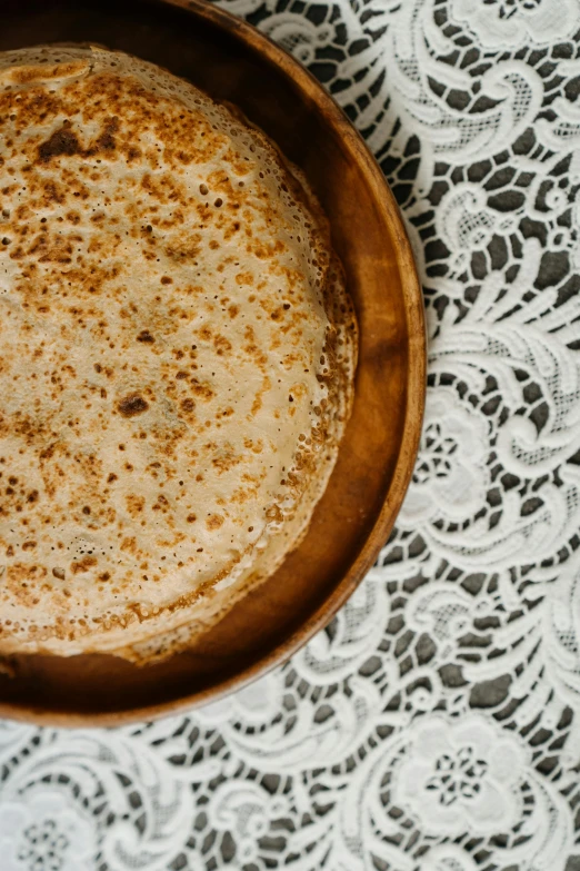 a close up of a bowl of food on a table, by Carey Morris, trending on unsplash, renaissance, flat pancake head, golden lace pattern, cinnamon, full frame image