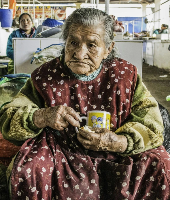 a woman sitting on top of a pile of luggage, a portrait, by Alejandro Obregón, pexels contest winner, cloisonnism, holding a tin can, the look of an elderly person, chile, markings on her face