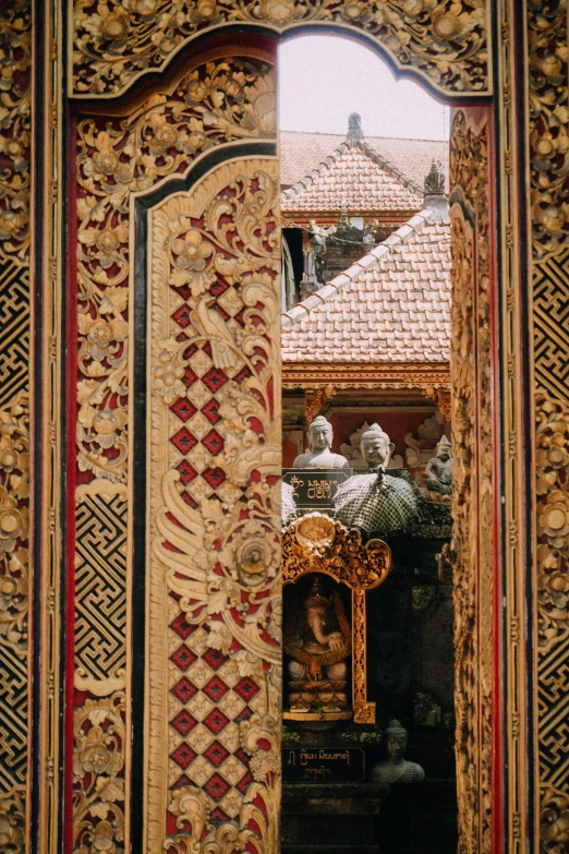 a close up of a mirror with a building in the background, a detailed painting, javanese mythology, gold and red filigree, geometric wood carvings, part of the screen