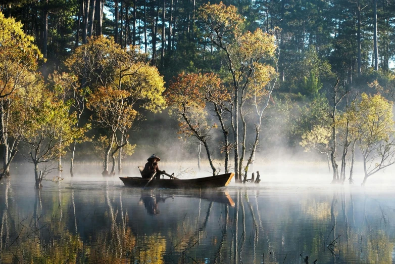 a person in a boat on a lake surrounded by trees, lpoty, fishing boats, award-winning-photograph, autumnal