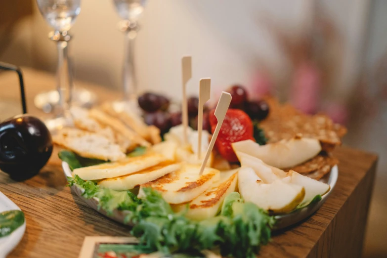 a wooden table topped with plates of food and wine glasses, pexels, private press, eating a cheese platter, background image, close - up photo, fruit bowl