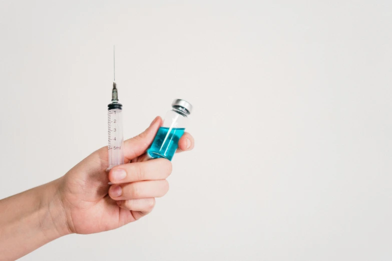 a person holding a syet in their hand, by Matija Jama, shutterstock, holding a syringe, blue colored, instagram post, on the white background