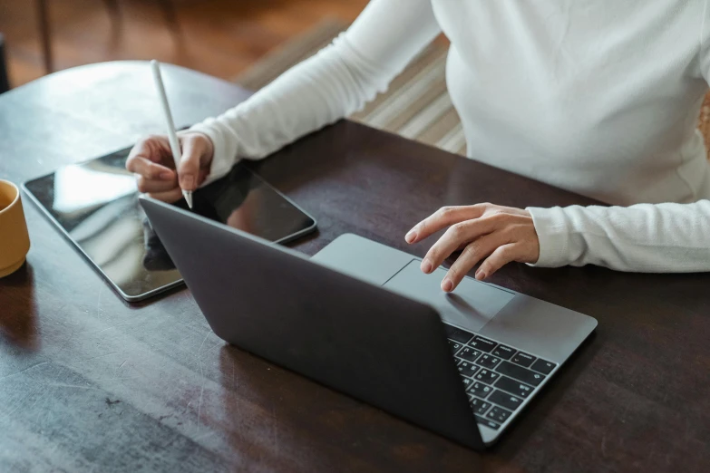 a woman sitting at a table using a laptop computer, by Carey Morris, trending on pexels, holding pencil, top-down shot, thumbnail, rectangle