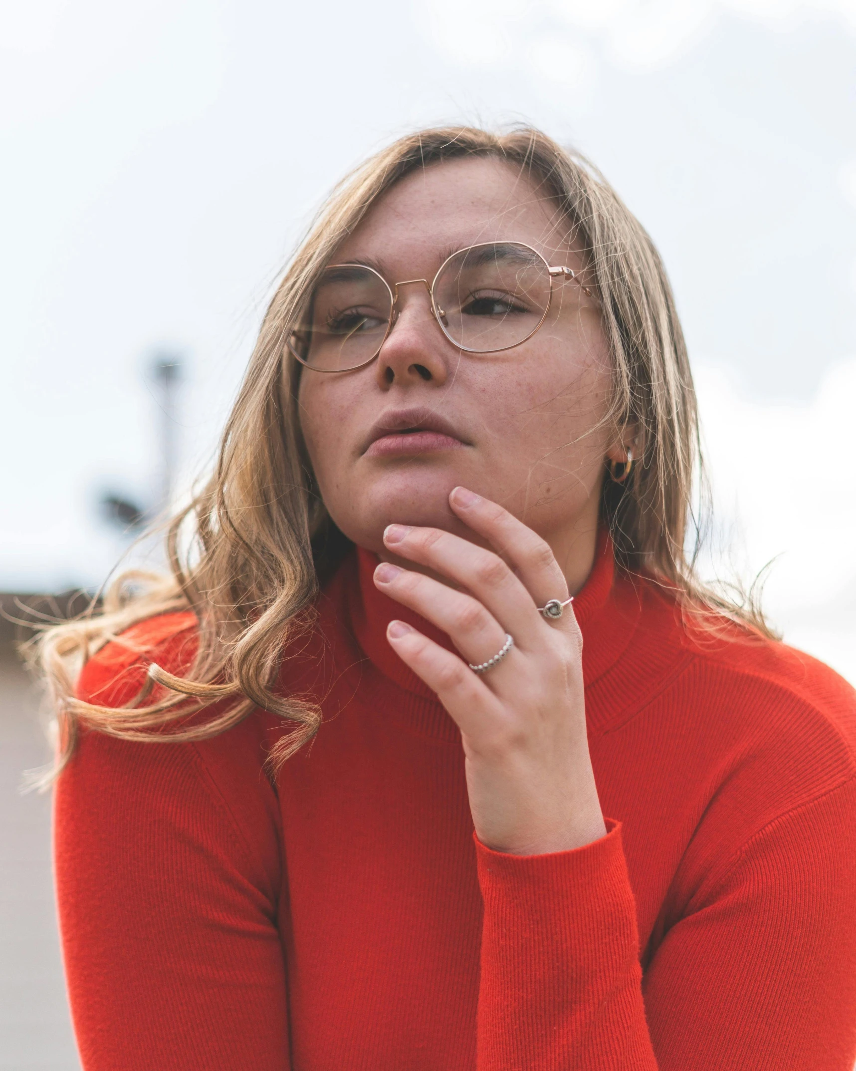 a woman wearing glasses and a red sweater, inspired by Elsa Bleda, trending on unsplash, happening, sydney sweeney, wearing two metallic rings, queer woman, wearing turtleneck