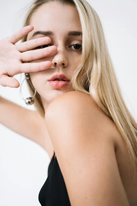 a woman covering her eyes with her hands, by Gavin Hamilton, trending on pexels, photorealism, long earrings, sleek blond hair, model エリサヘス s from acquamodels, 1 6 years old