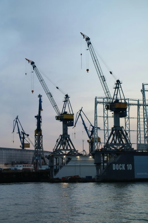 a large ship sitting on top of a body of water, a photo, by Jacob Koninck, flickr, constructivism, huge machine cranes, having a good time, taken in the late 2010s, huge support buttresses