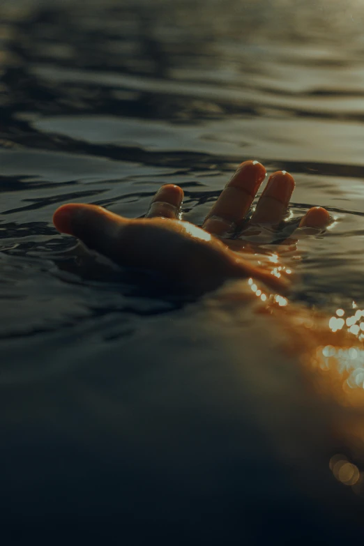 a person floating on top of a body of water, an album cover, inspired by Elsa Bleda, unsplash, hand of fear, tragedy, morning hour, help me