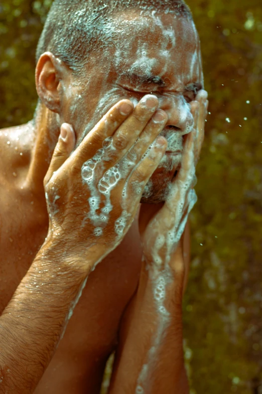 a man is shaving his face with soap, by Elsa Bleda, pexels, renaissance, covered in water drops, tan skin, holding his hands up to his face, slide show