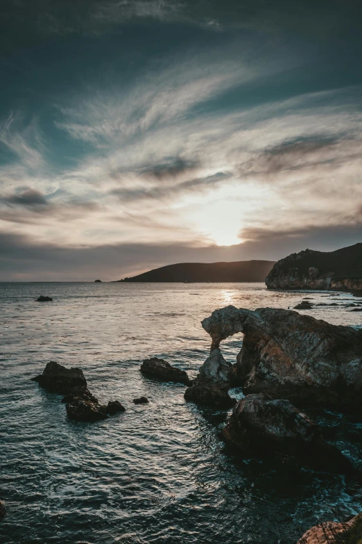 a sunset over the ocean with rocks in the foreground, pexels contest winner, hollister ranch, island with cave, today\'s featured photograph 4k, grey