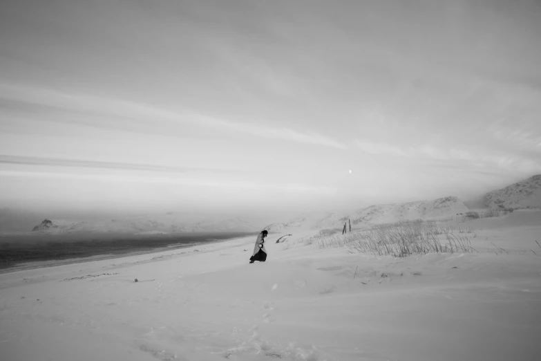 a man riding a snowboard down a snow covered slope, a black and white photo, by Emma Andijewska, desolate arctic landscape, sittin, on moon, uploaded