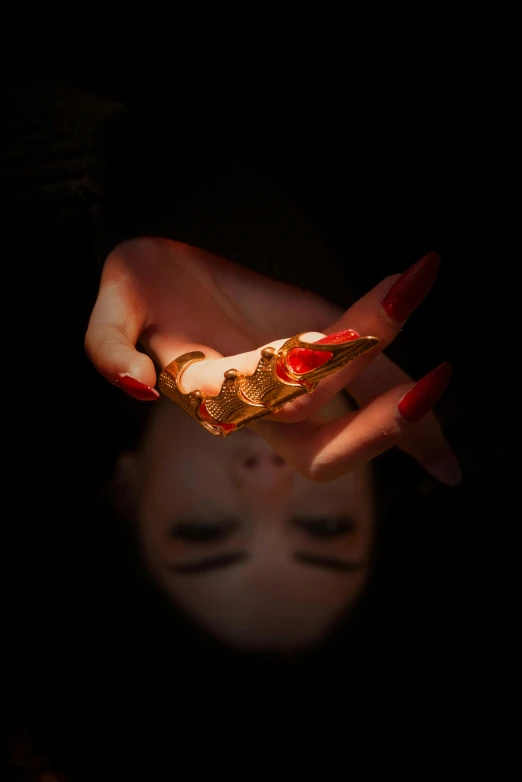 a close up of a person holding a piece of food, inspired by Hedi Xandt, art photography, chaumet style, red and cinematic lighting, dragon fangs, **cinematic