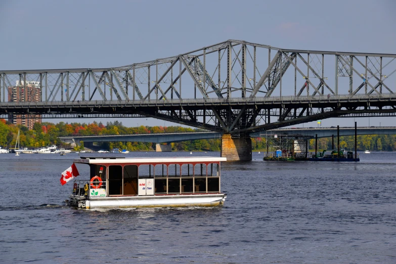 a boat on a body of water with a bridge in the background, quebec, in 2 0 1 5, fully functional, guide