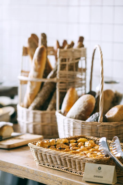 a table topped with lots of different types of bread, pexels, french provincial furniture, great light, college, tall