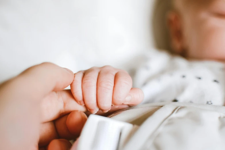 a close up of a person holding a baby, with index finger, nursing, uploaded, no watermarks