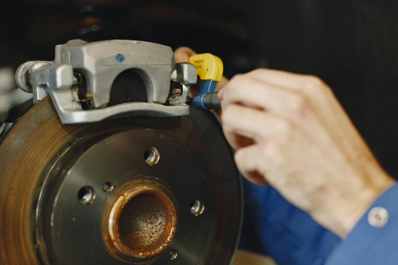 a close up of a person working on a brake, a portrait, liam brazier, coloured, high quality product image”, pistons and bolts