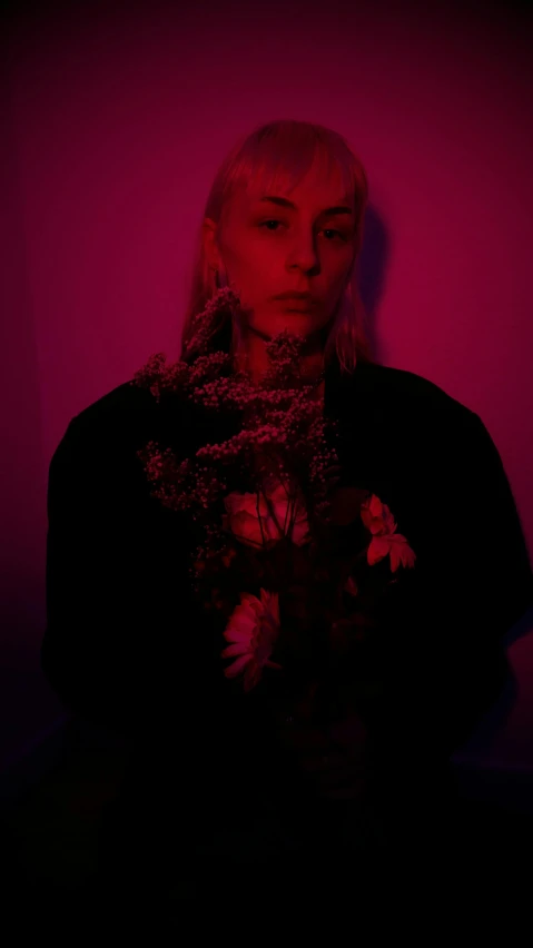 a woman standing in front of a pink wall, an album cover, inspired by Elsa Bleda, unsplash, antipodeans, in front of a black background, neon flowers, intense albino, low quality photo