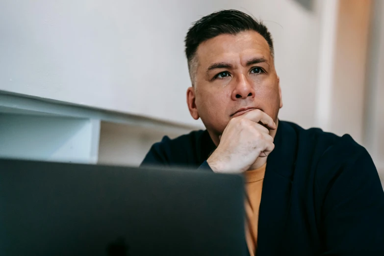 a man sitting in front of a laptop computer, a photo, trending on pexels, realism, looking serious, 4 0 years old, youtube thumbnail, professional closeup photo