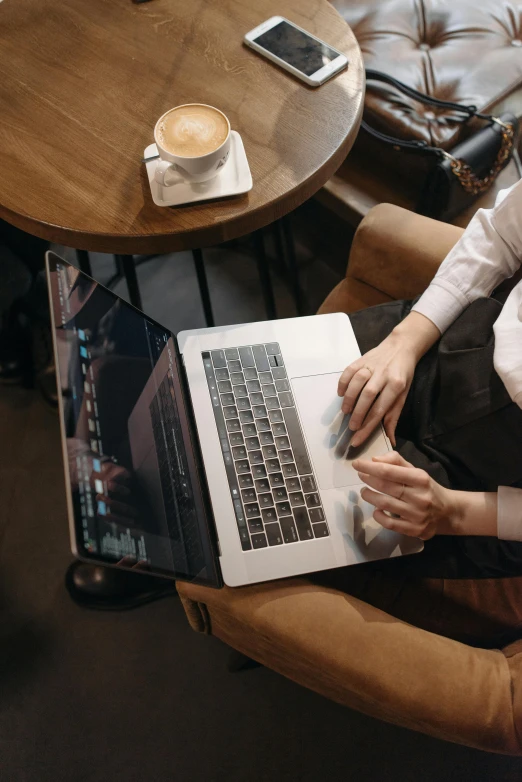 a woman sitting in a chair using a laptop, trending on pexels, top-down shot, with a laptop on his lap, detailed professional, thumbnail