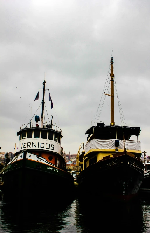 a couple of boats that are sitting in the water, the raining city of lisbon, victorian fire ship, up close, two