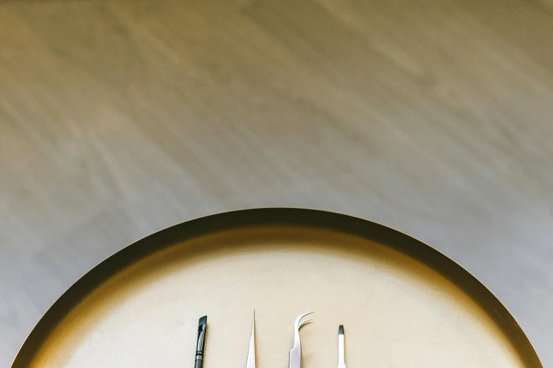 a pair of scissors sitting on top of a table, inspired by Lucio Fontana, trending on pexels, metal lid, ochre, silver，ivory, chefs table