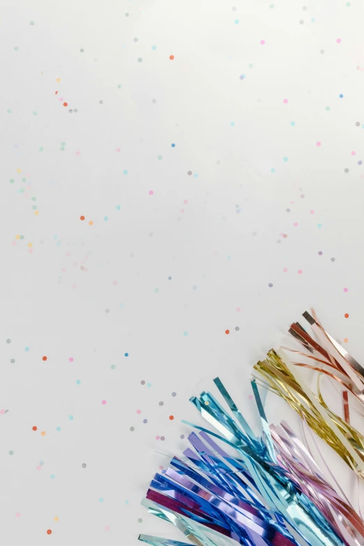 a pair of scissors sitting on top of a table, confetti, minimalistic aesthetics, multiple colors, white backdrop